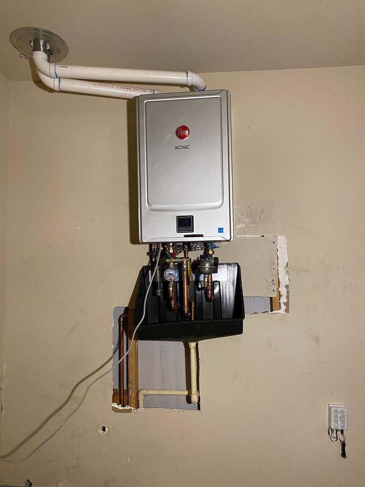 A water heater is hanging from the ceiling in a room.