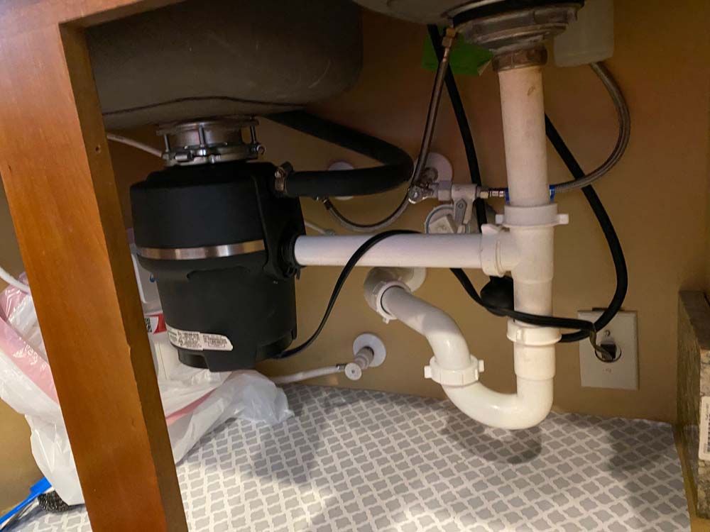 A kitchen sink with a garbage disposal underneath it.