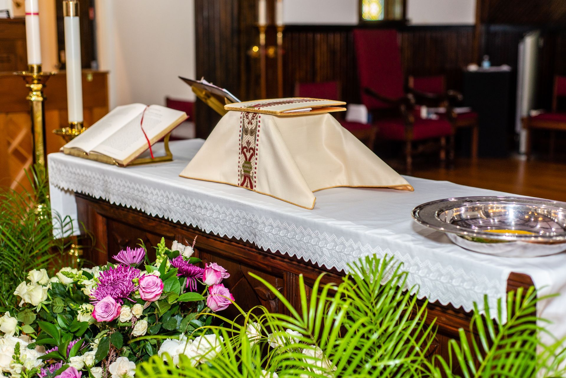 An altar in a church with flowers and a bible on it.
