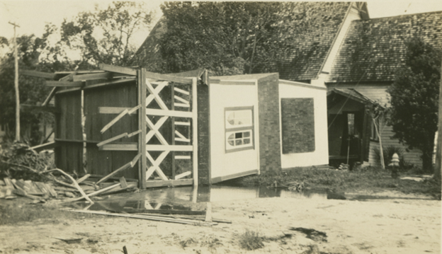 A silver cross is sitting on a wooden table.