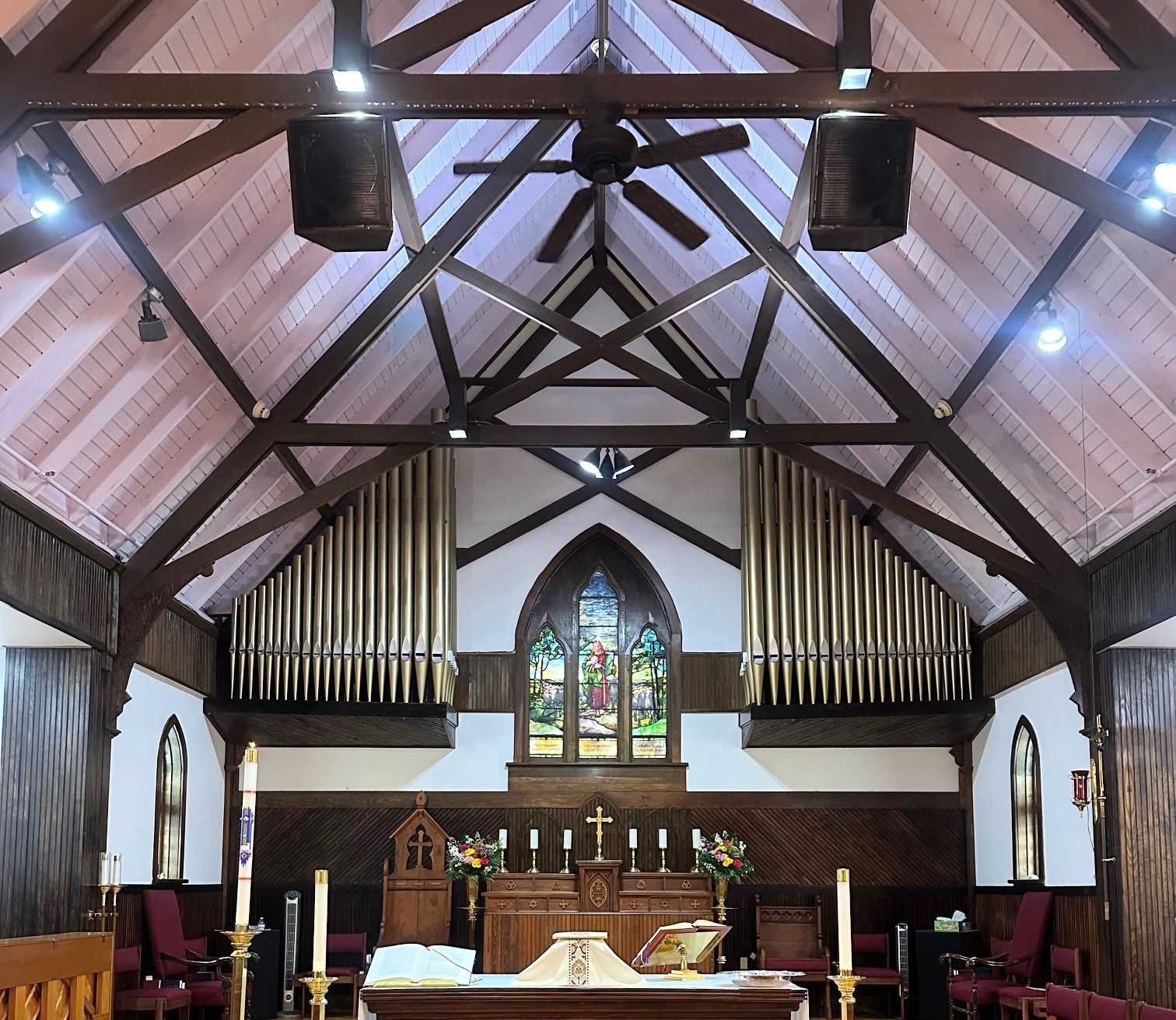 A church with a ceiling fan and a stained glass window