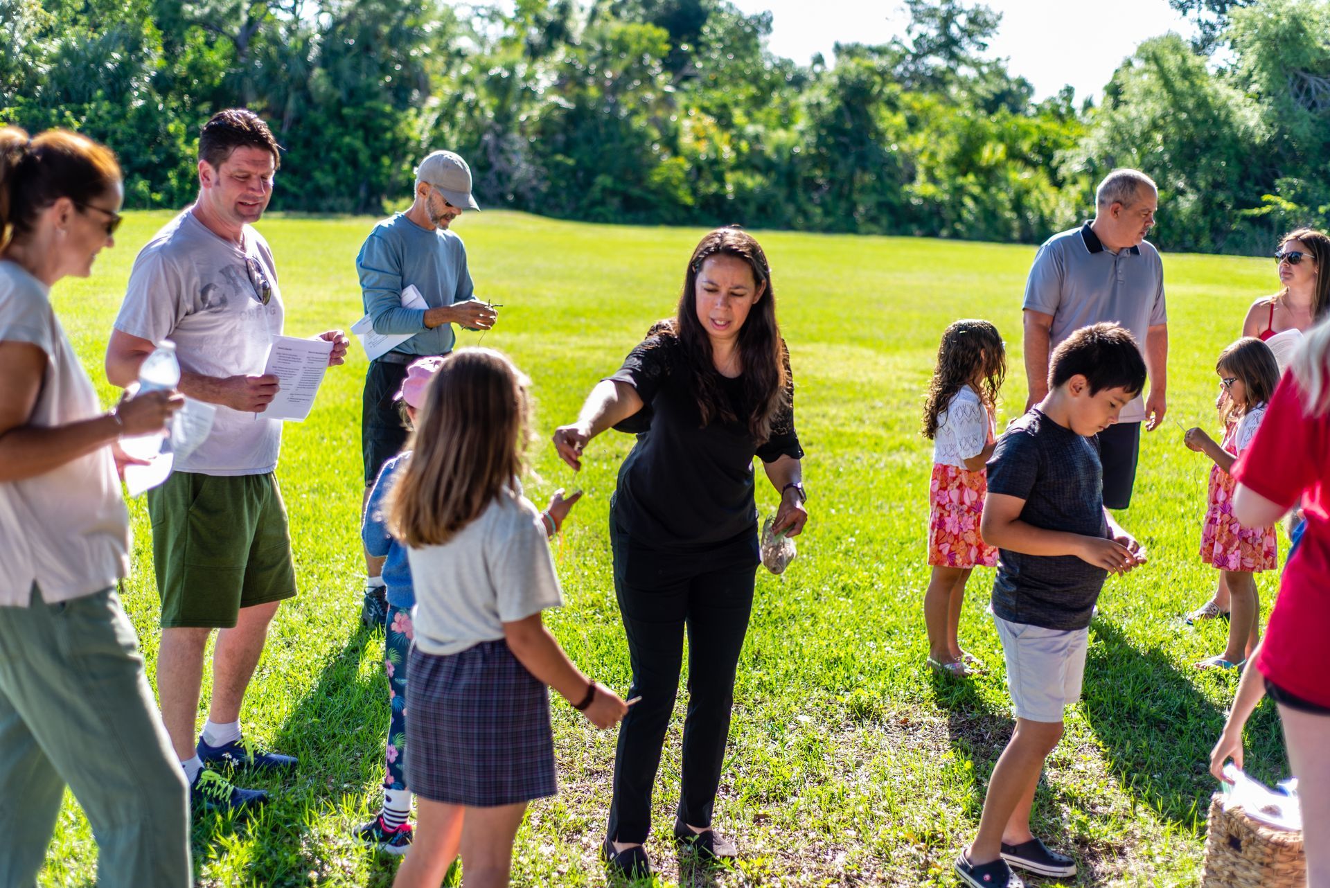A group of people are standing in a field holding hands.