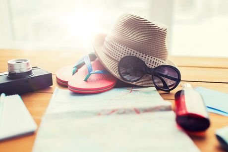 summer vacation, tourism and objects concept - close up of travel map, airplane tickets, money and personal accessories