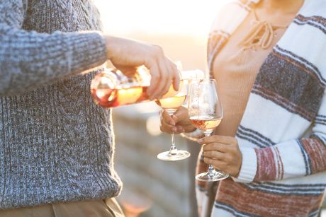 Man and woman with glass of rose wine on summer beach picnic