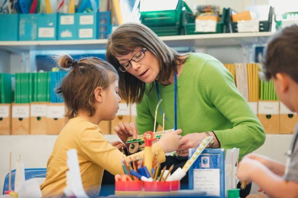 A group of children are raising their hands in a classroom to answer a question.