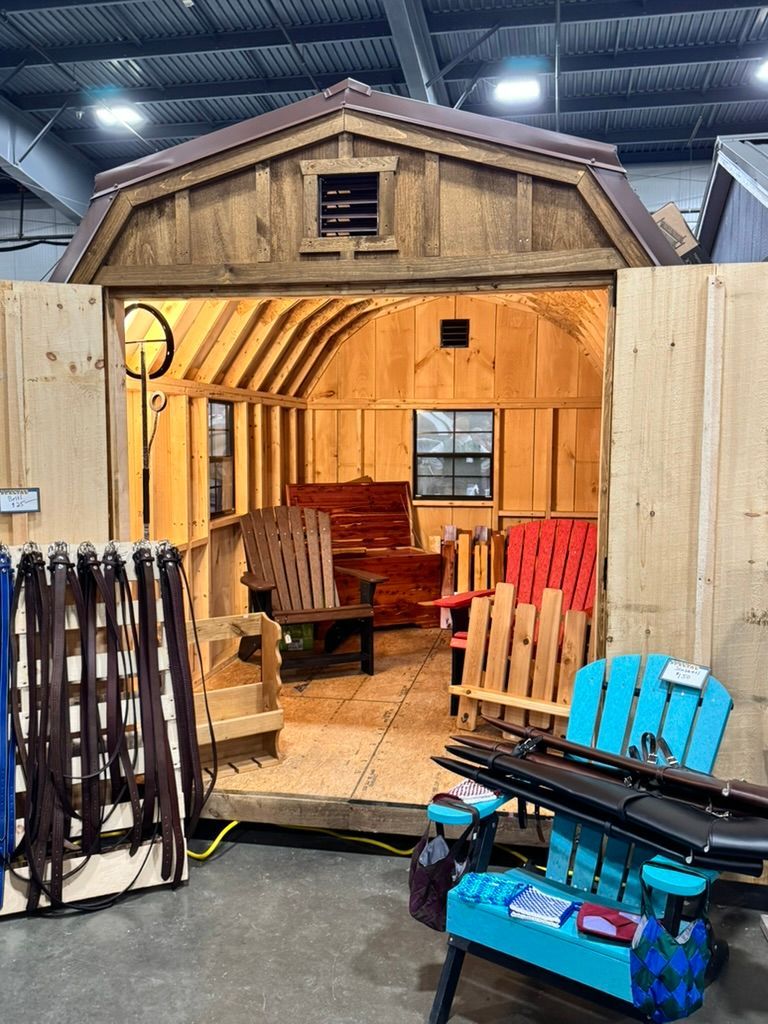 Wooden shed interior with chairs on display at an event.