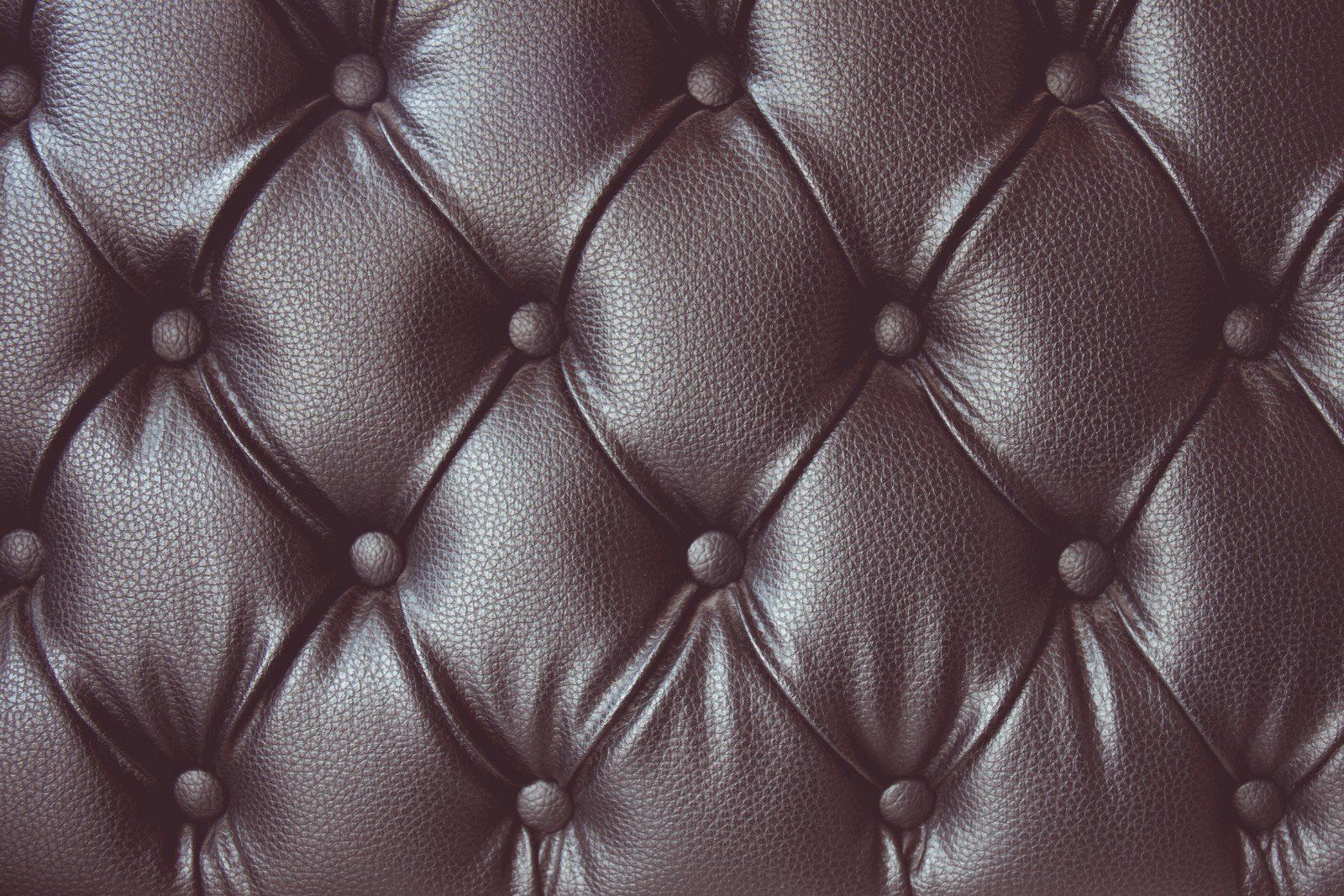 Primo piano della arazzi di pelle di un sofà con abbottonatura e pieghe