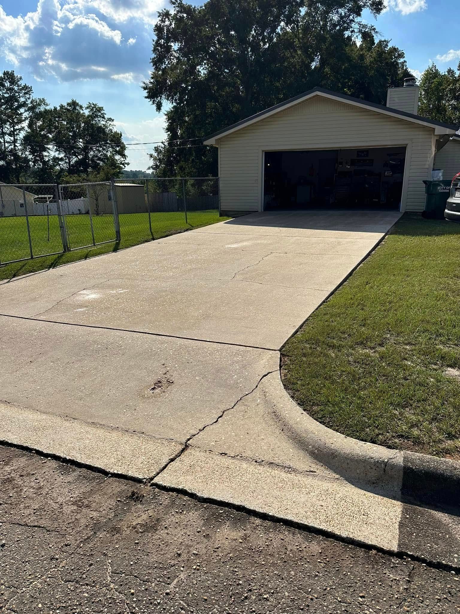 A driveway leading to a garage with a car parked in front of it.