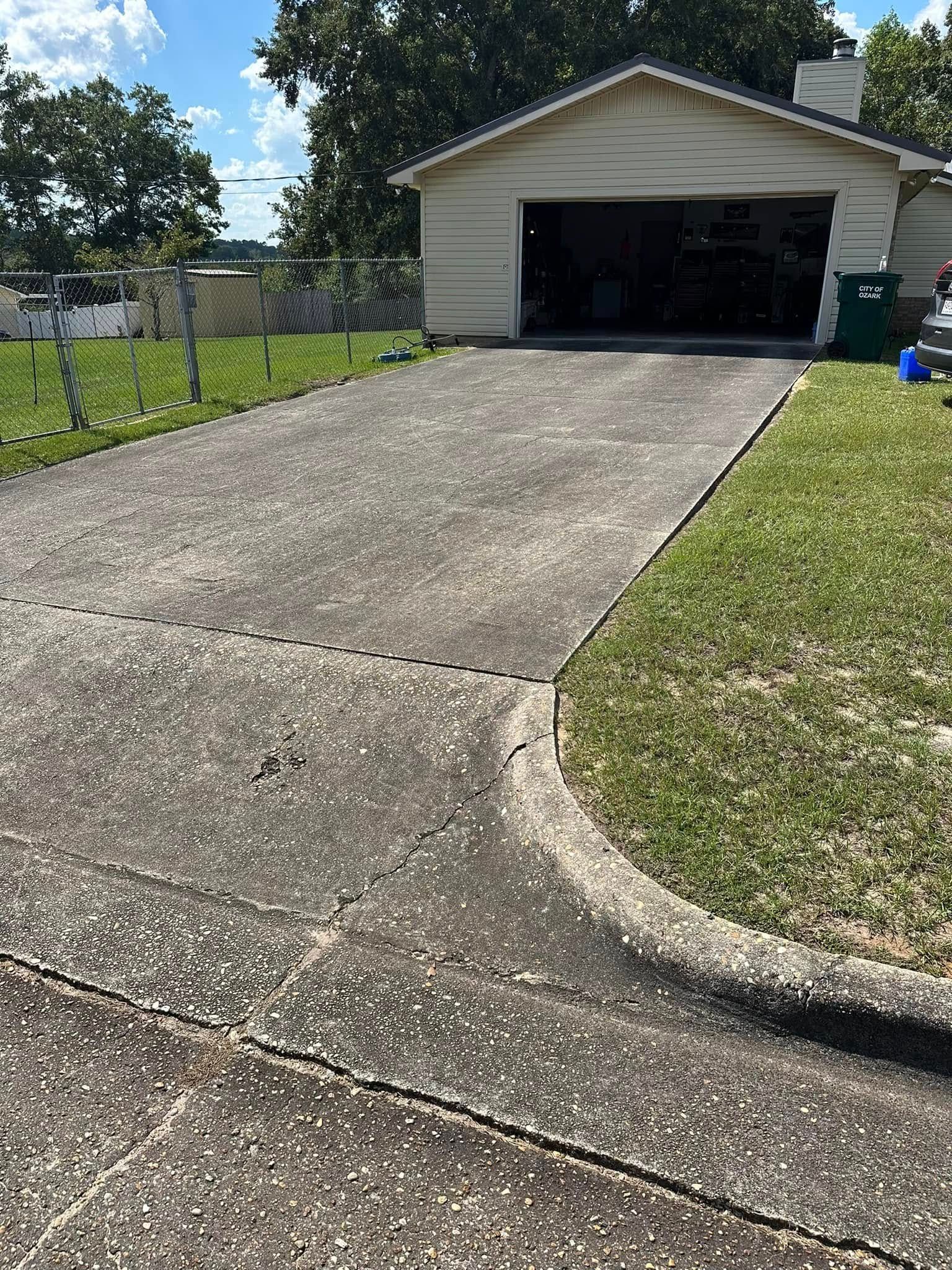 A concrete driveway leading to a house with a garage.