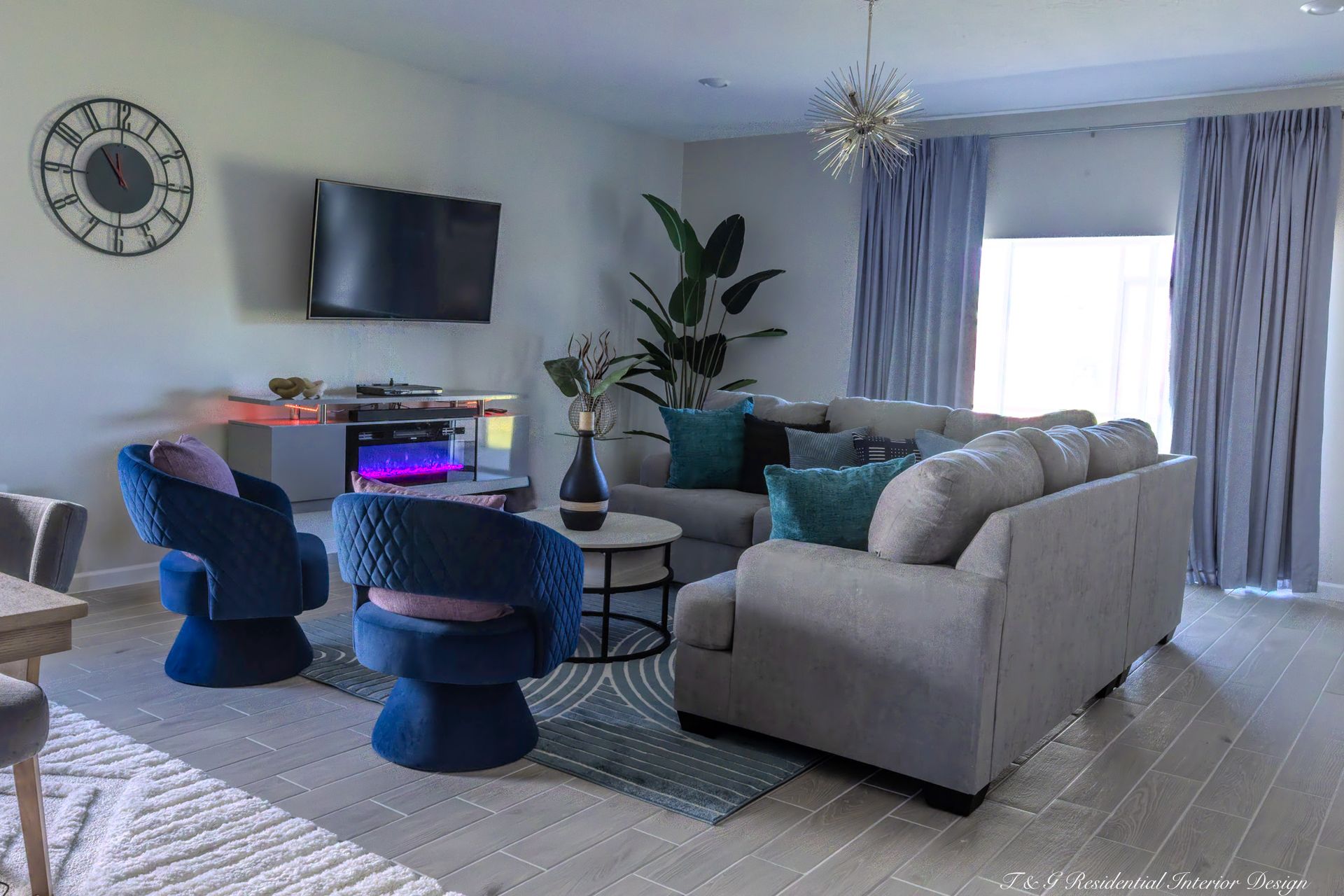 A living room with a couch, chairs, and a plant.