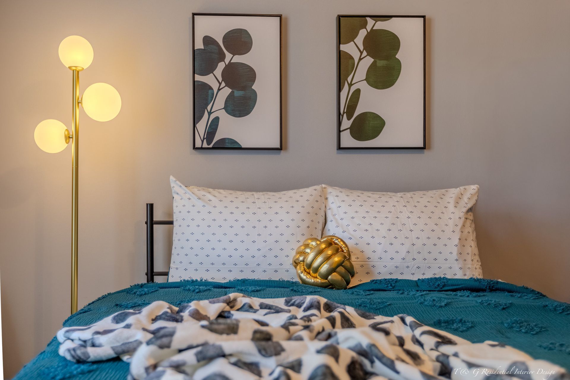 Bedroom with a bed, throw pillows, and a teal blanket.