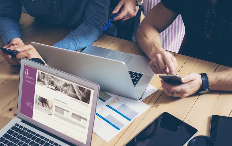 A Group Of People Are Sitting At A Table With Laptops And Phones — D-stress Computers In Idalia, QLD
