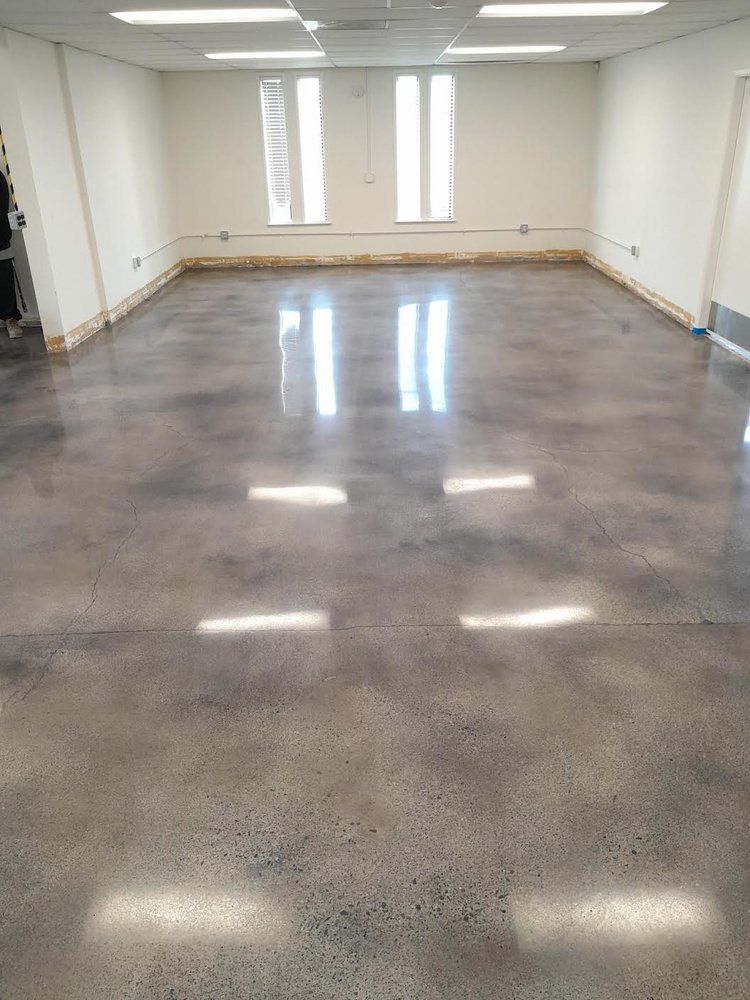A large room with a shiny concrete floor and white walls.