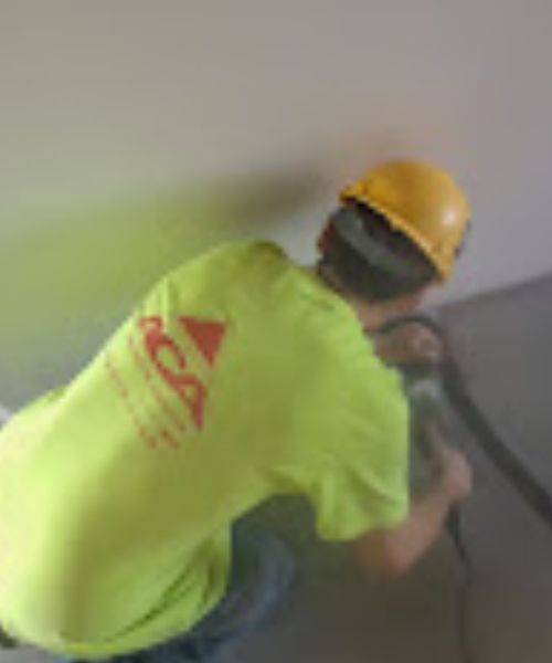 A yellow mop is sitting on a tiled floor in a room