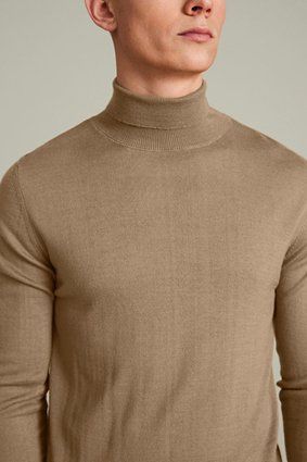Man wearing a tan turtleneck sweater.