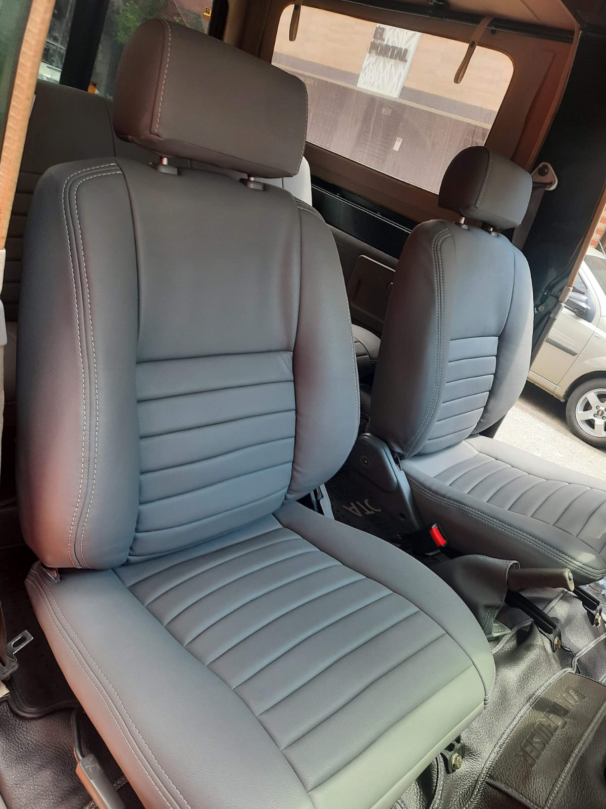 Un par de fundas de asiento de cuero gris en un coche.