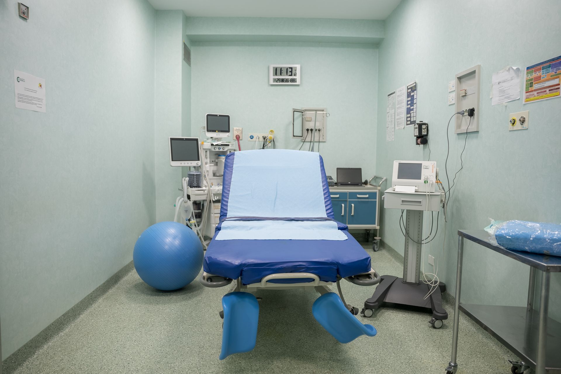 Una sala operatoria vuota con un letto blu e una palla blu