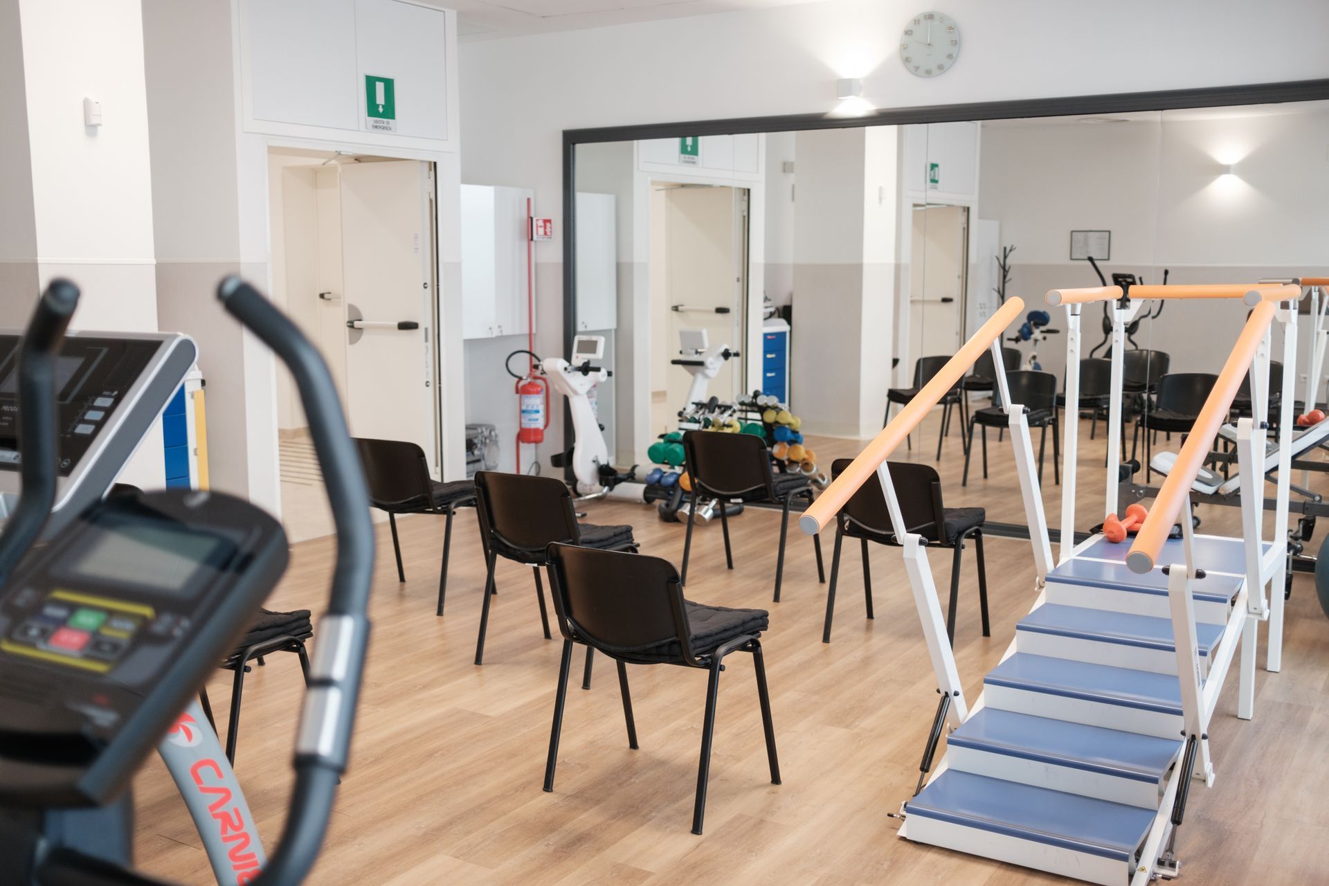 Un gruppo di sedie è sistemato in una palestra.