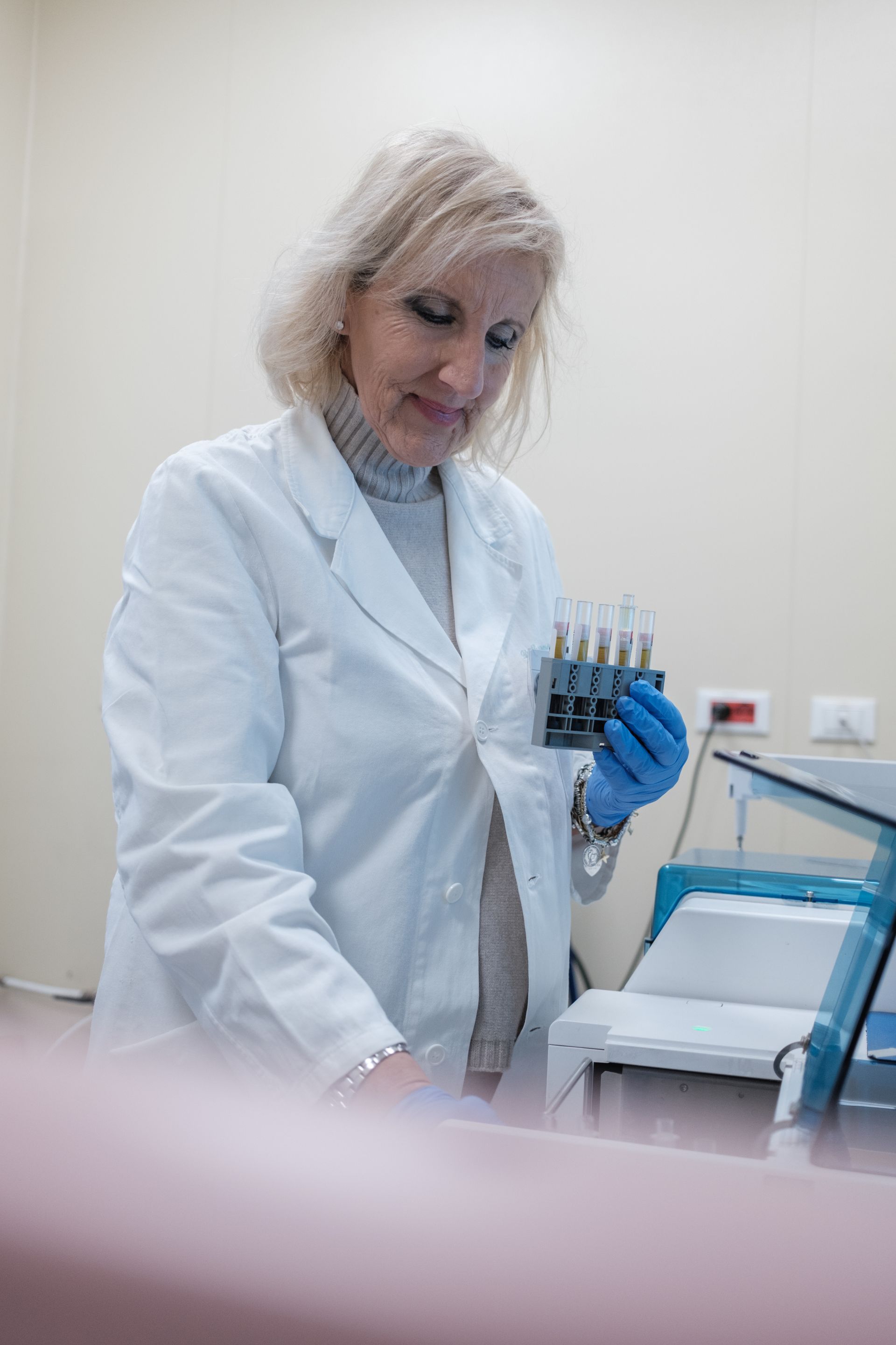 Una donna in camice lavora in un laboratorio.