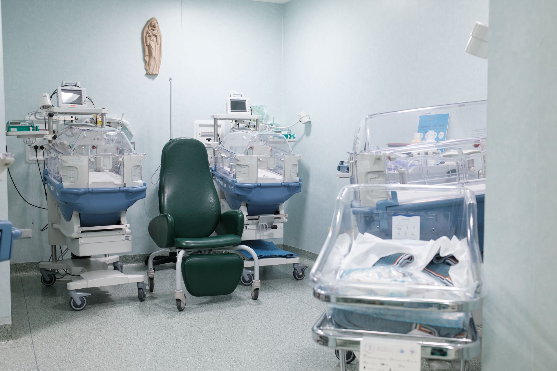 Una stanza d'ospedale con due incubatrici e una sedia.