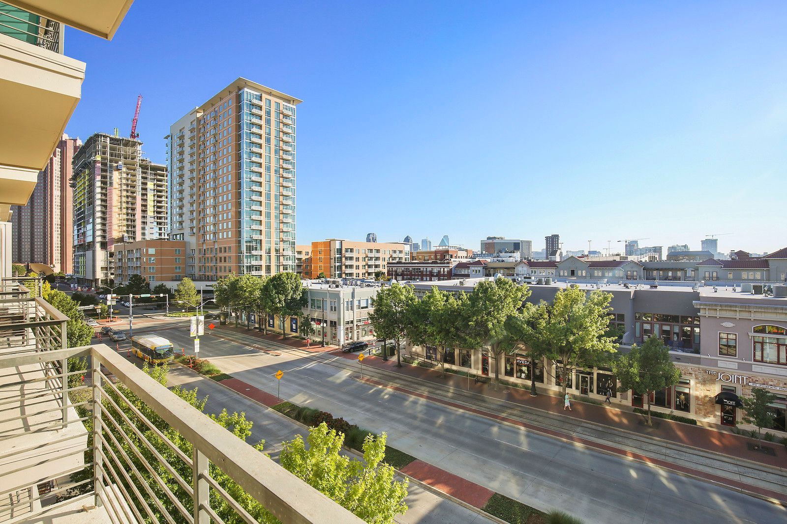 A view of a city from a balcony with trees and buildings in the background