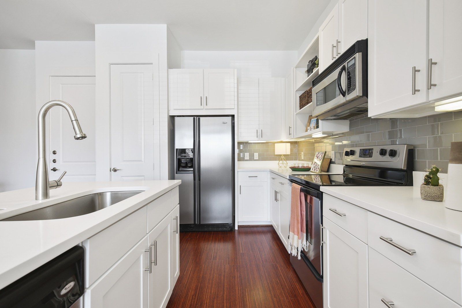 A kitchen with white cabinets and stainless steel appliances