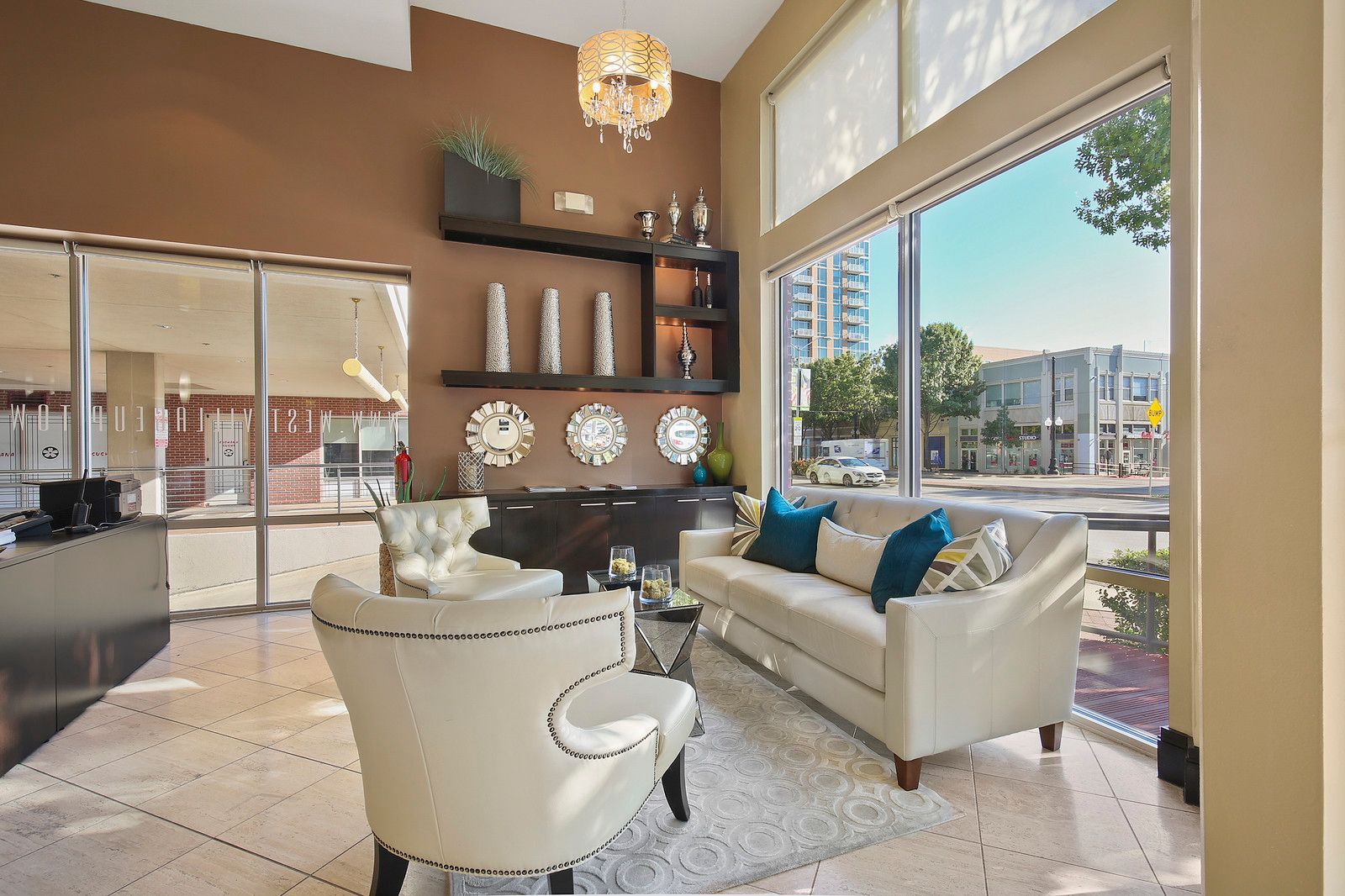 A living room with a couch , chairs , and a large window.