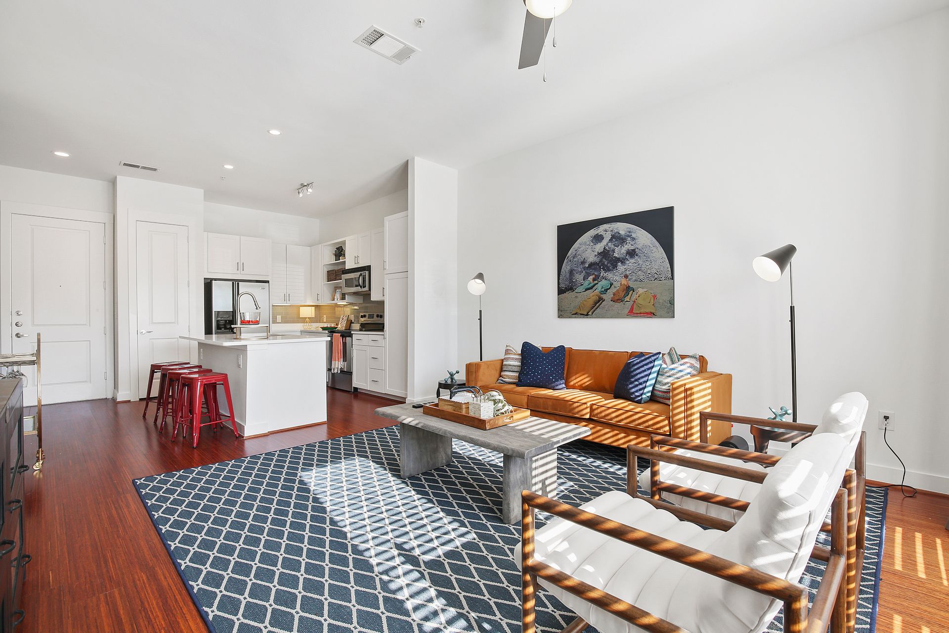 A living room with a couch and chairs and a rug