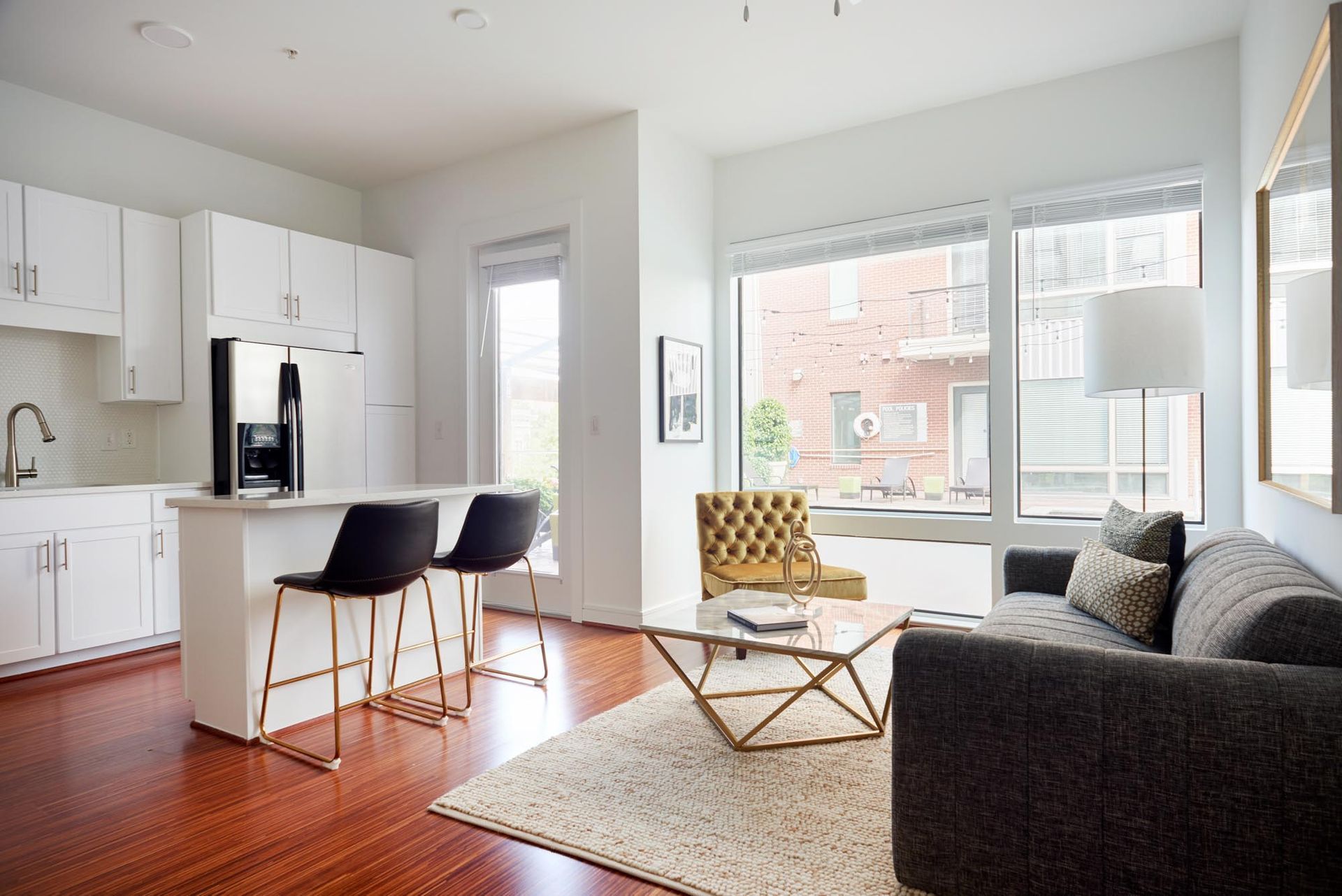 A living room with a couch , coffee table , chairs and a kitchen.