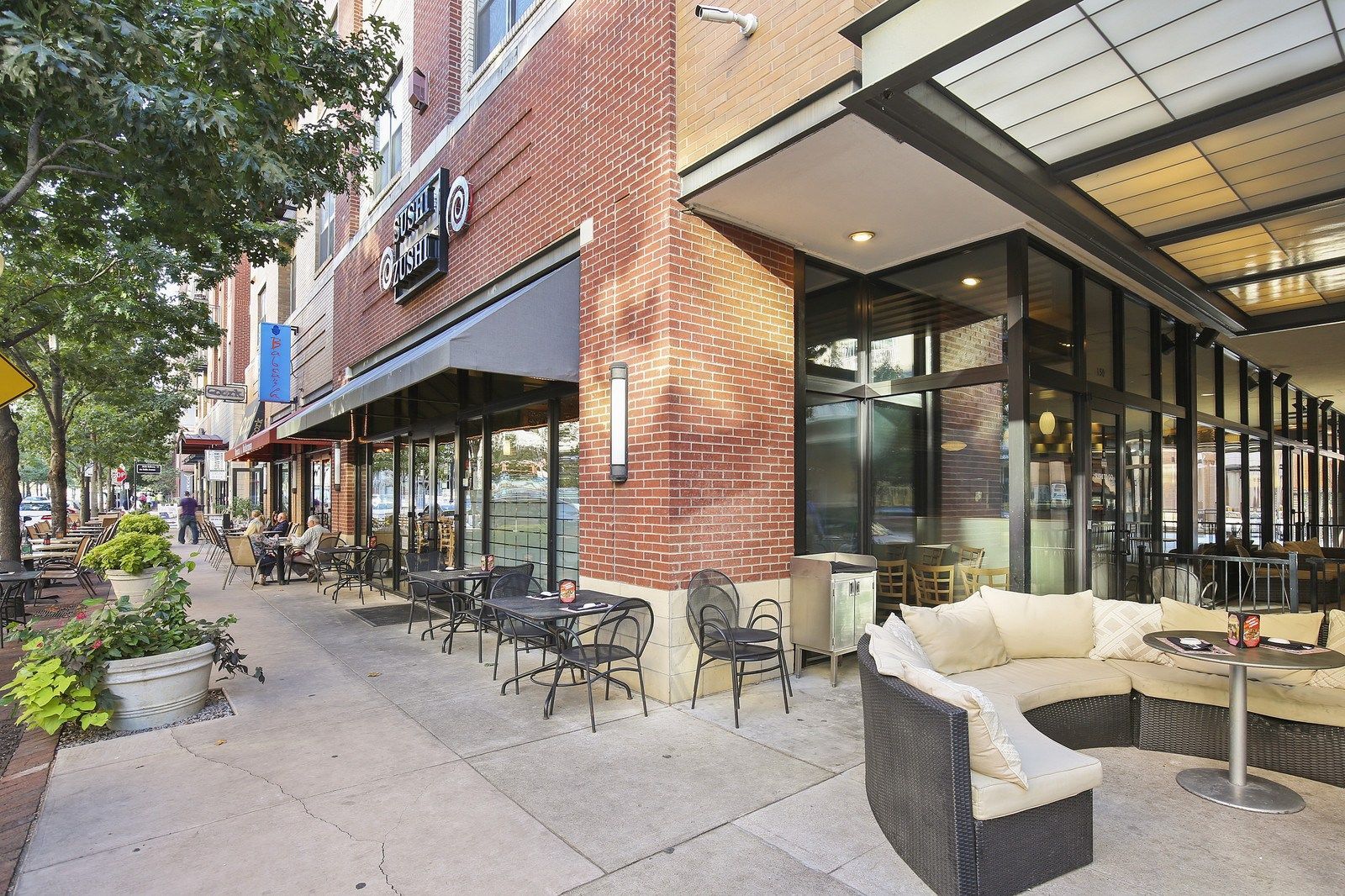A restaurant with tables and chairs outside of it
