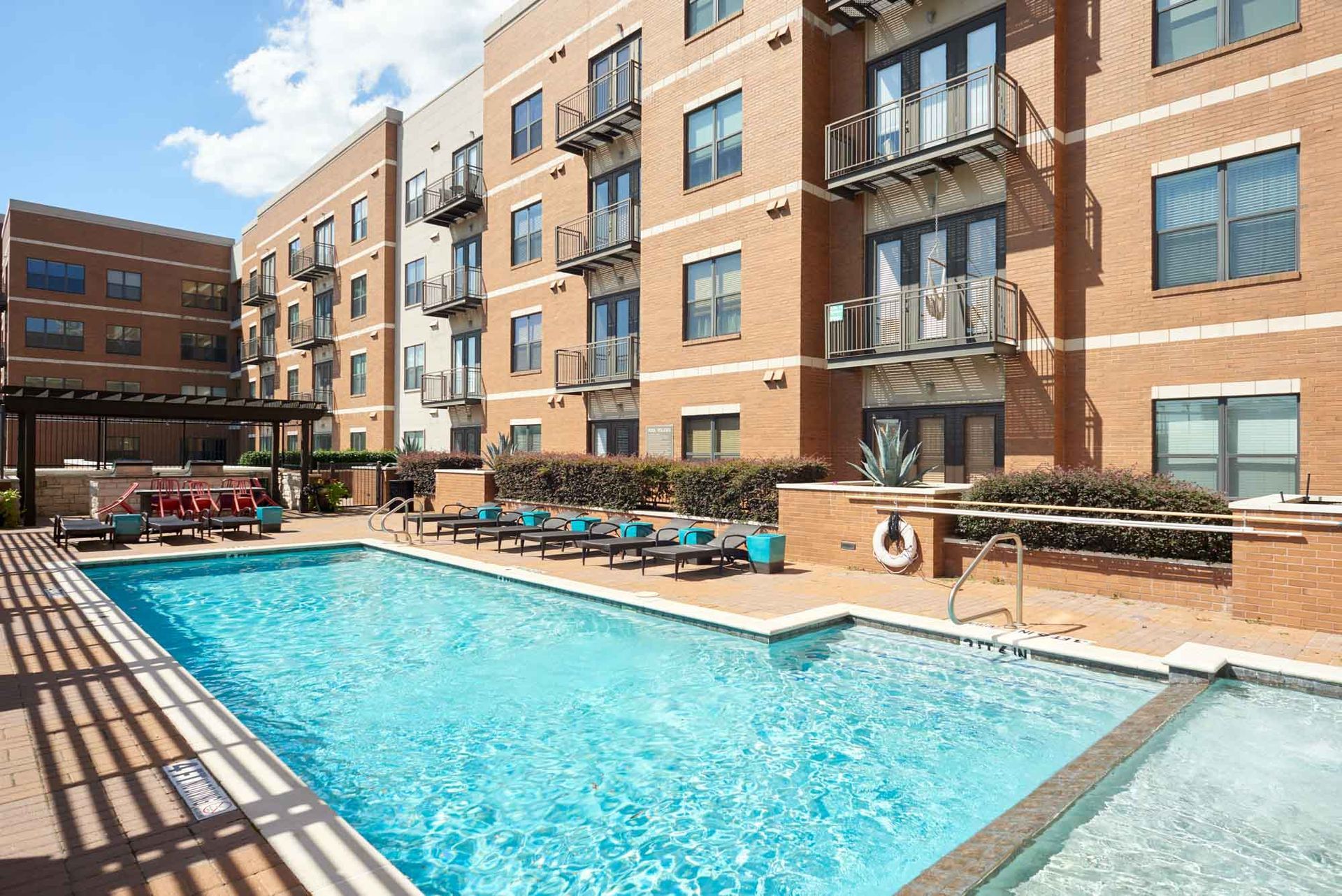 A large swimming pool in front of a brick building.