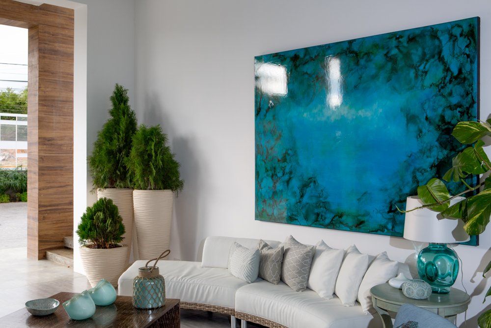 Lobby de H2Otel by LD con sofá blanco, arte abstracto y detalles en madera, creando un espacio acogedor y elegante.