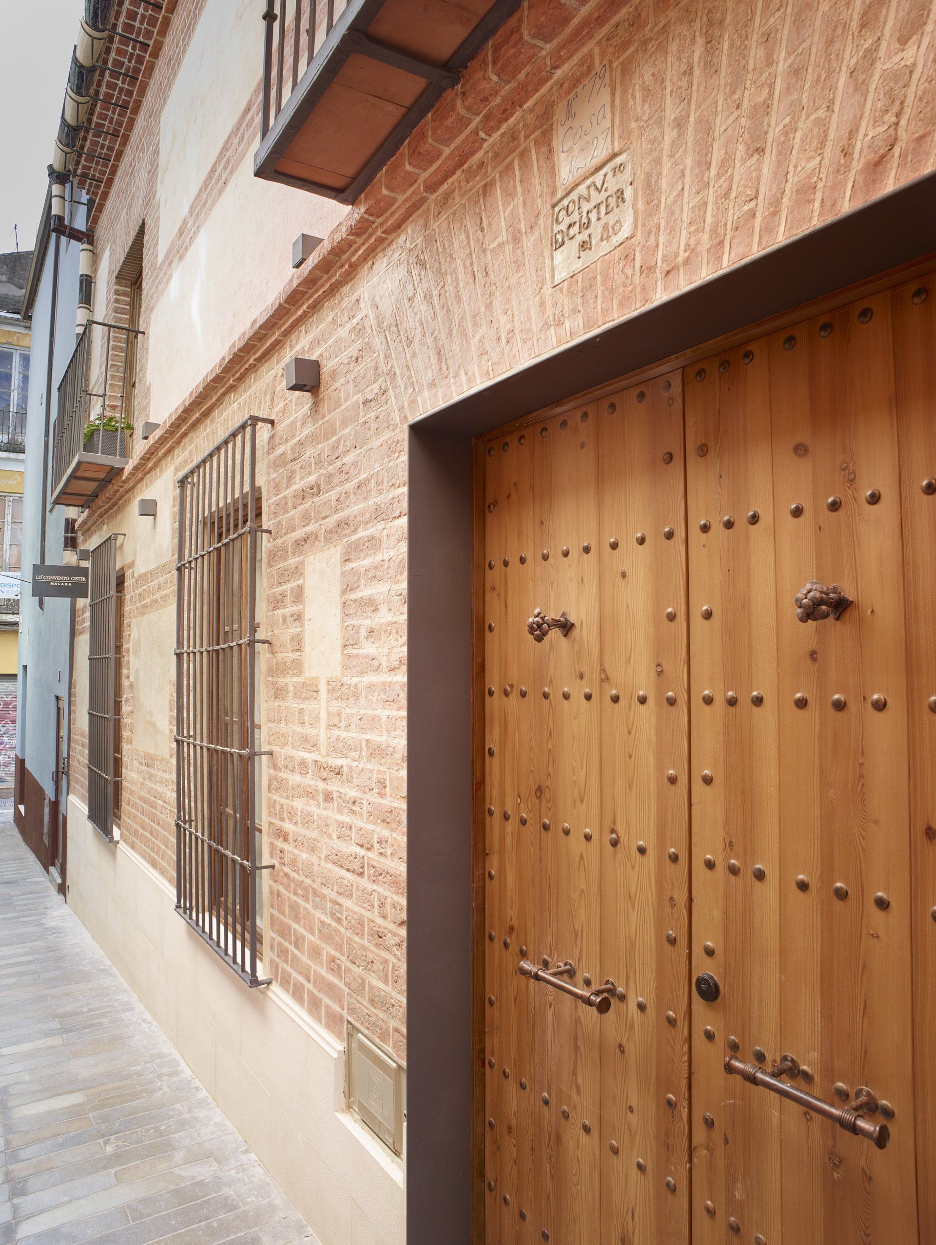 Fachada del hotel LD Convento Cister Málaga, con puerta de madera histórica y detalles arquitectónicos rústicos.