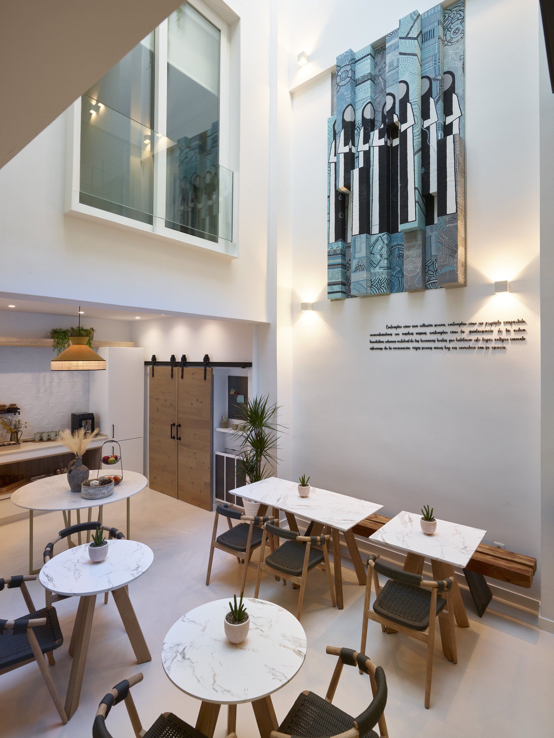 Vista aérea del lobby del hotel LD Convento Cister Málaga, con diseño moderno, alfombra geométrica y plantas decorativas.