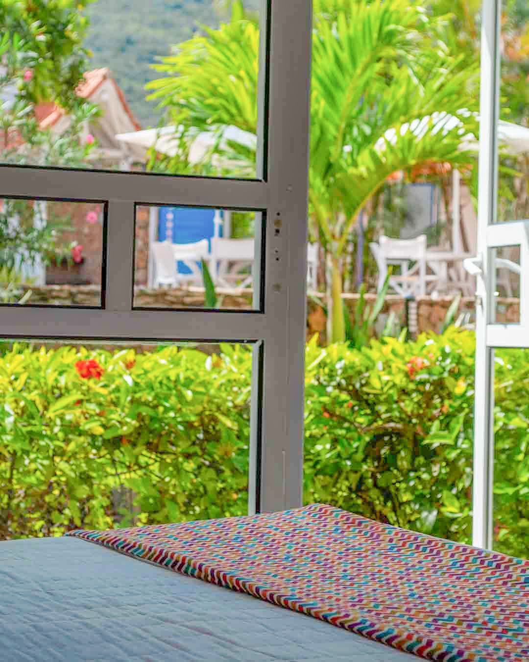 Habitación cuádruple en LD Palm Beach, Playa El Agua, con dos camas dobles y decoración cálida y moderna.