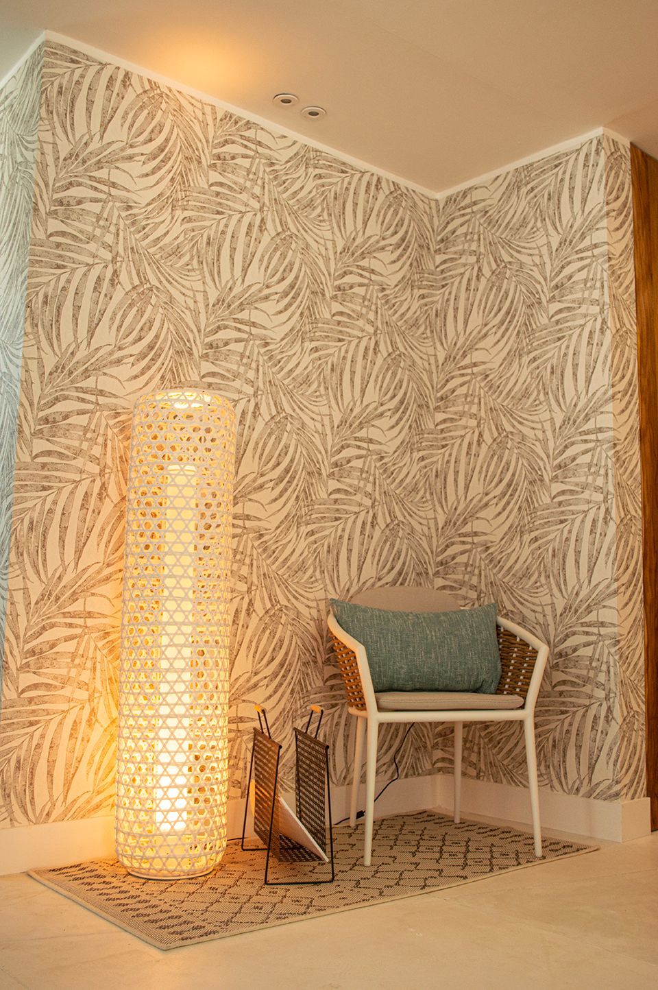 Lobby tropical en Sabbia by LD, Los Roques, con pared de hojas y lámpara de pie decorativa.