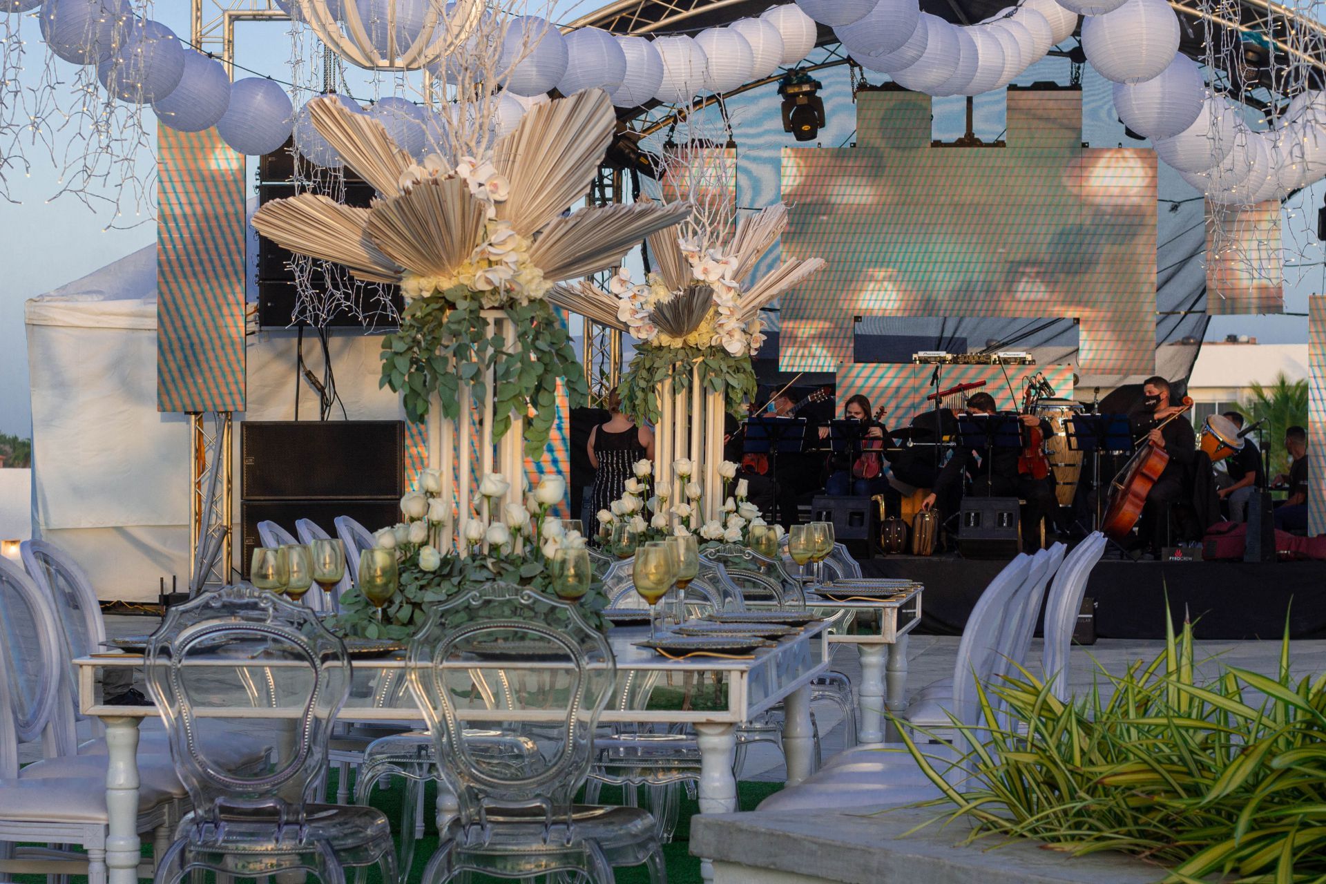 Mesas decoradas para evento al aire libre en terraza LD PLUS, con sillas transparentes y centro floral.