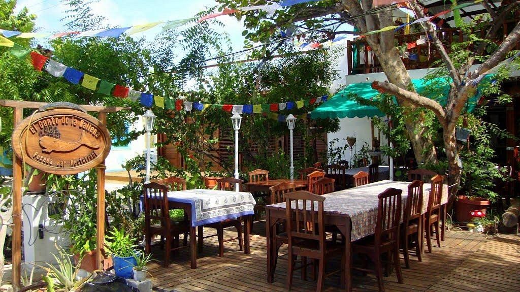 Restaurante El Canto de la Ballena en Los Roques, rodeado de vegetación tropical y ambiente festivo.