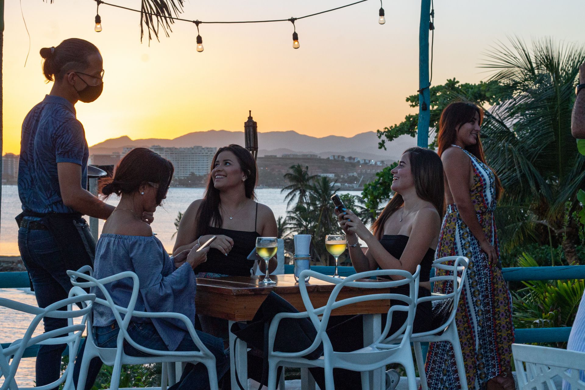 Atardecer dorado en Restaurante Guayoyo, con mujeres disfrutando la cena, Isla Margarita.