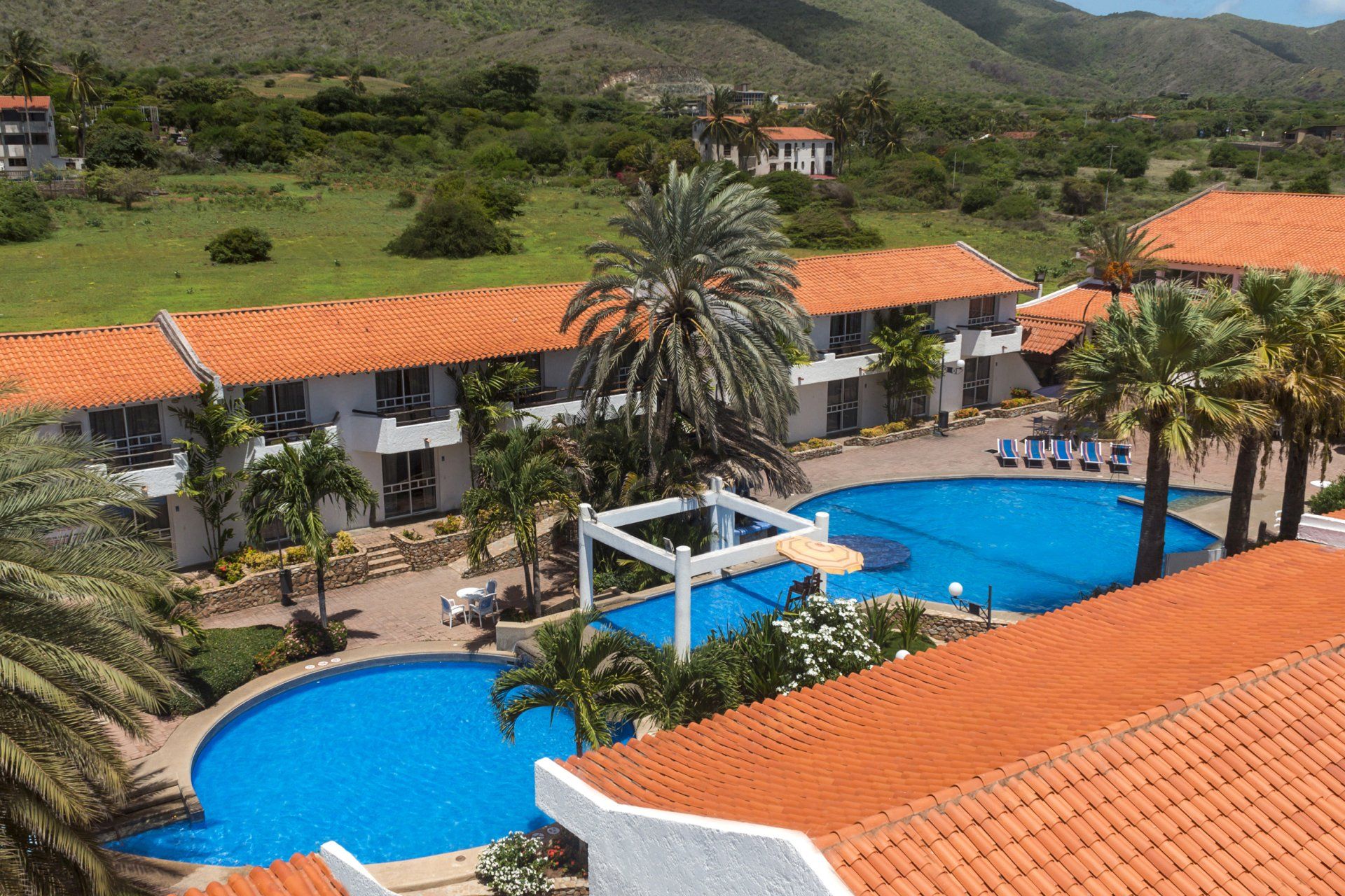 Vista aérea de las piscinas del hotel LD Palm Beach, con múltiples piscinas azules