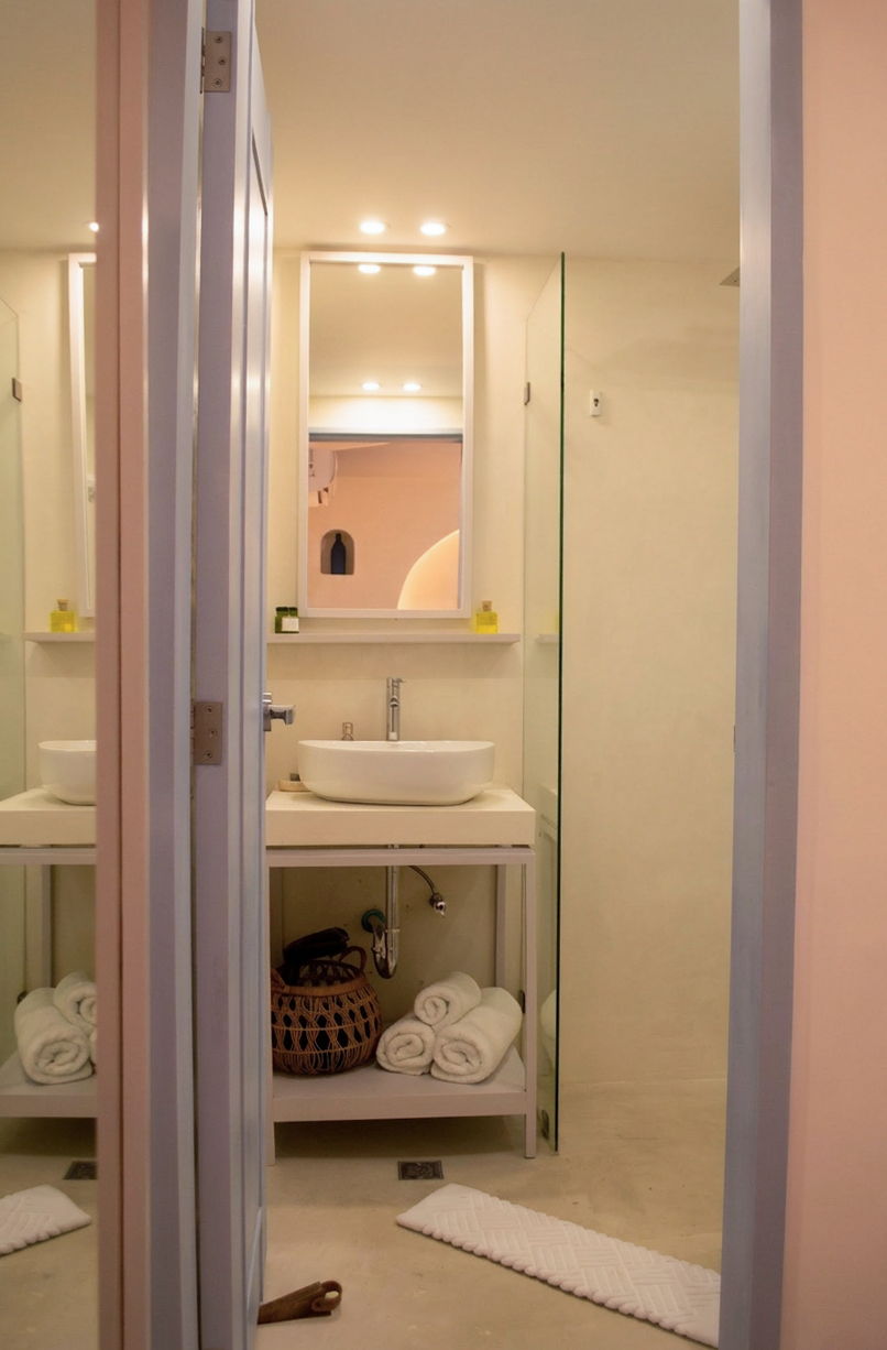 Baño moderno con lavabo, inodoro y ducha con patrones geométricos en azul y gris.