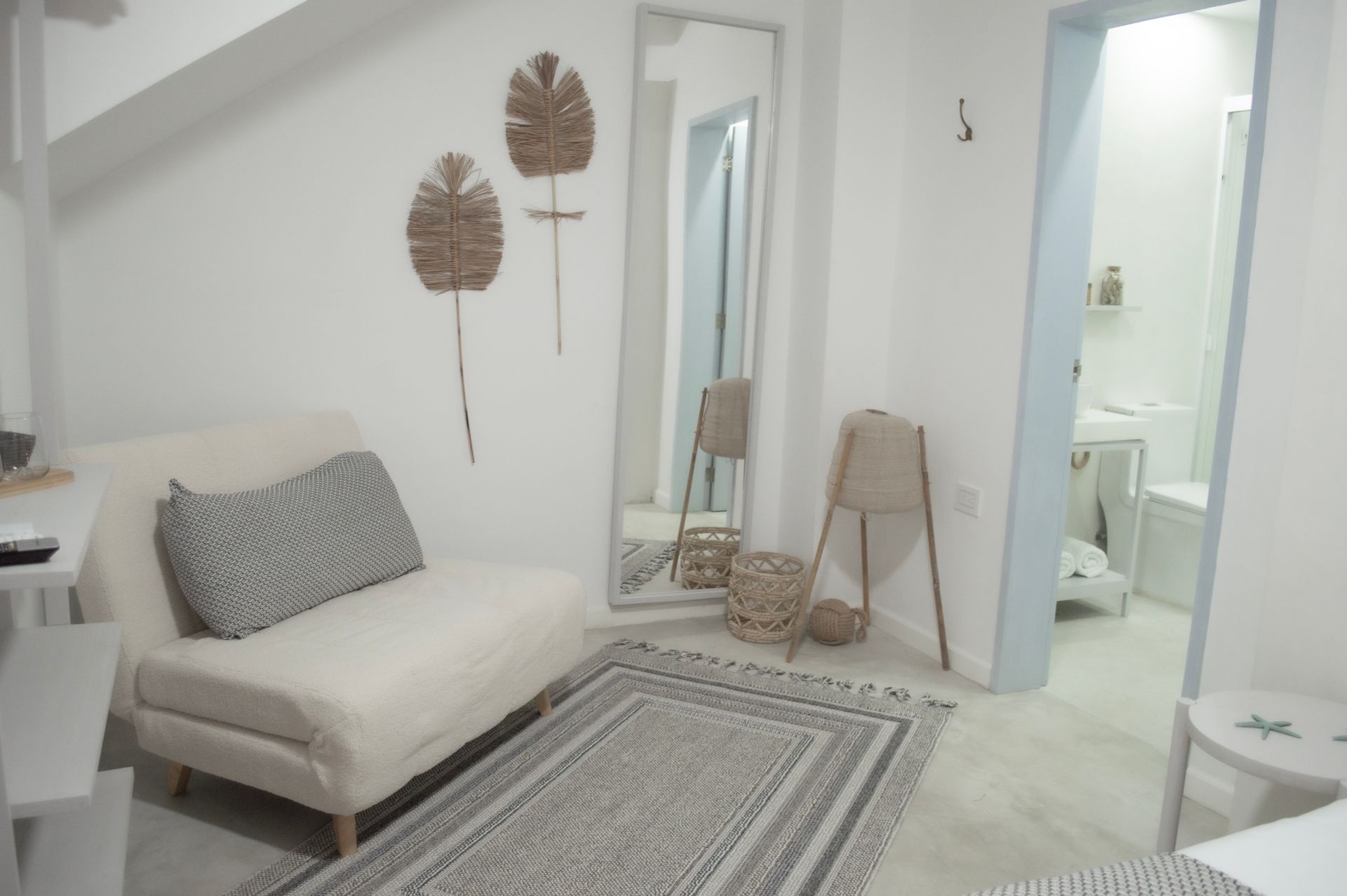 Habitación moderna y minimalista en Hotel Laguna by LD Hoteles, con sofá beige y decoración natural.