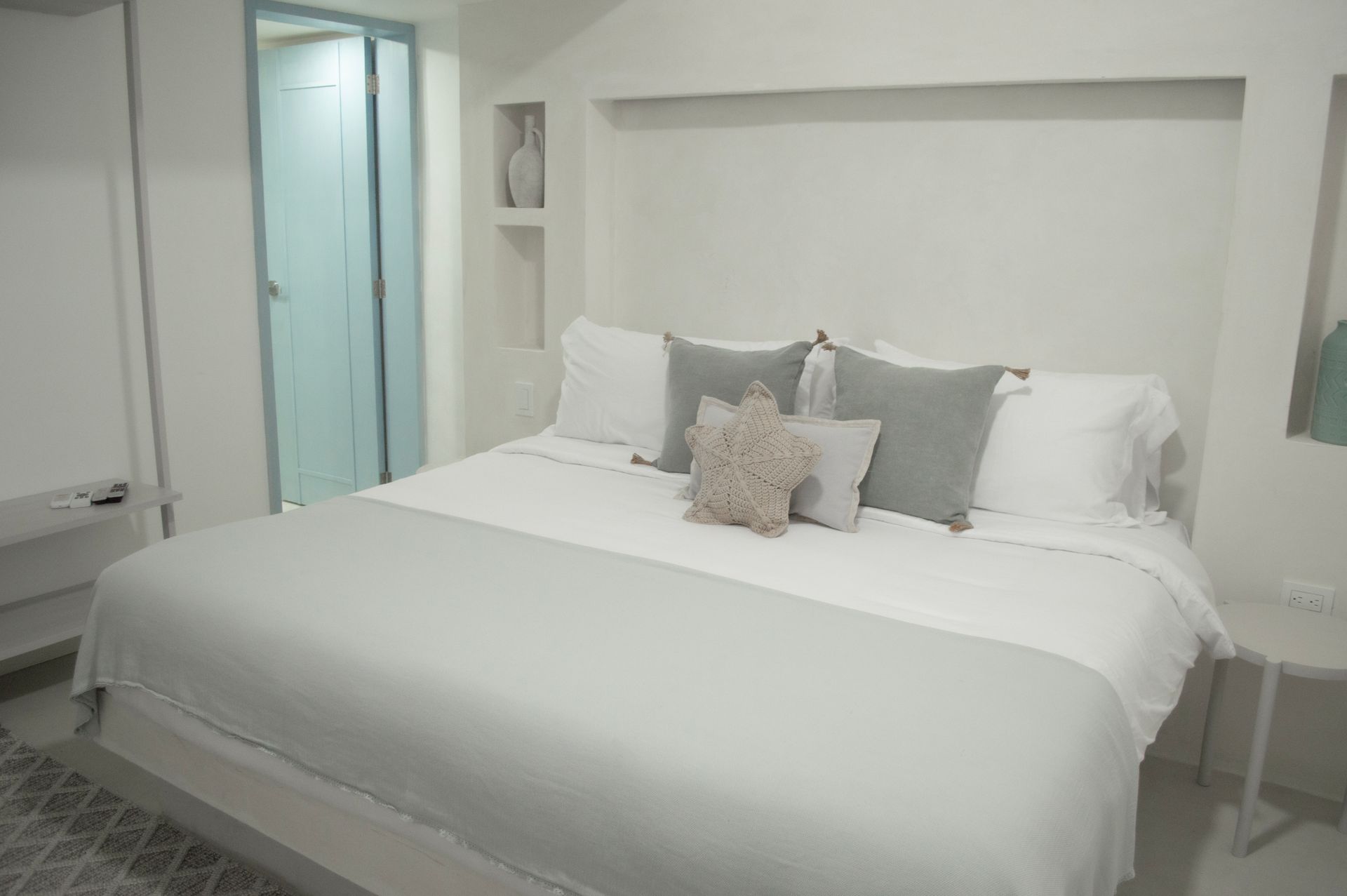 Habitación moderna y minimalista en Hotel Laguna by LD Hoteles, con cama grande y decoración elegante.