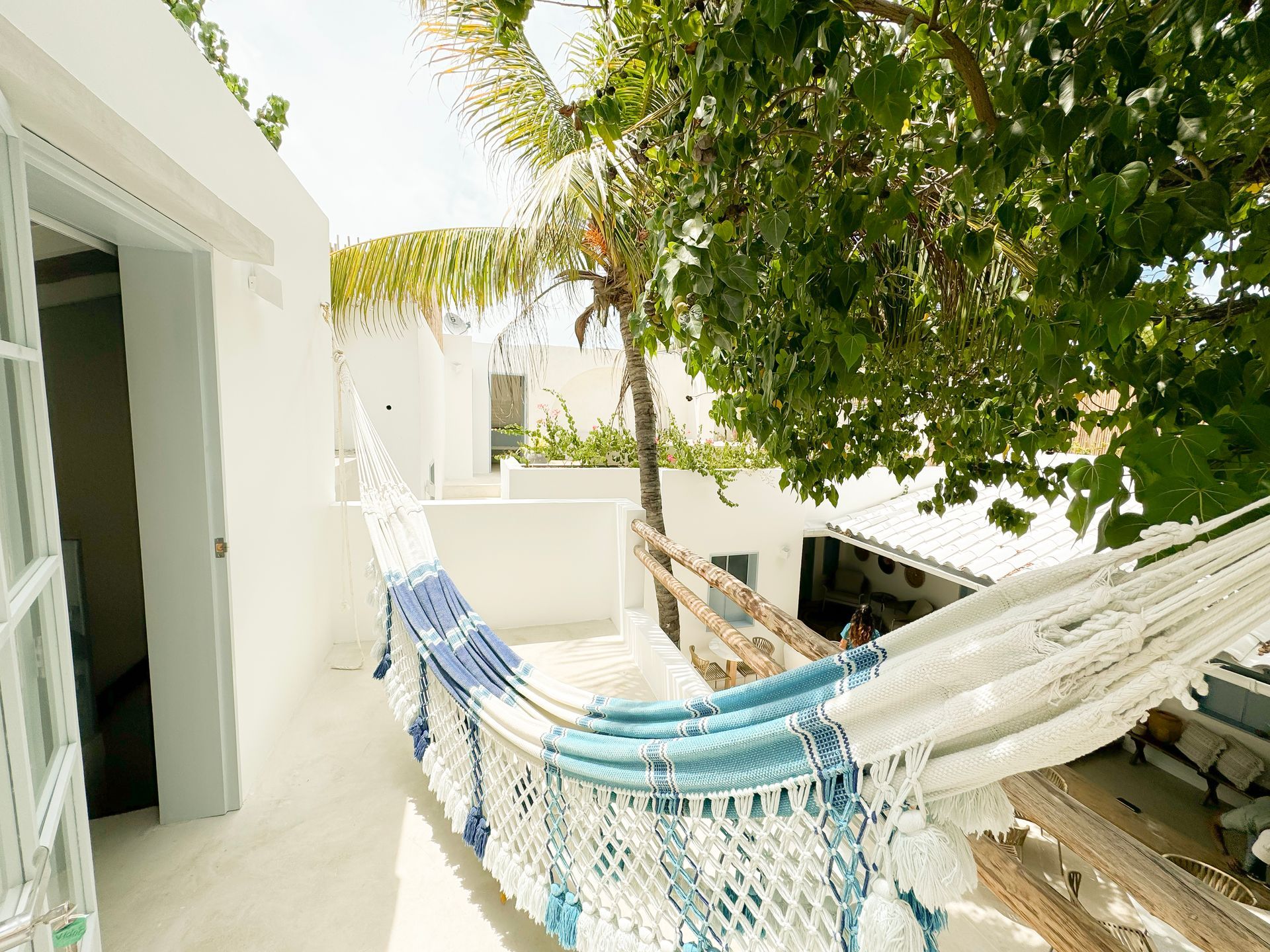Hamaca blanca con rayas azules en área exterior del Hotel Laguna by LD.