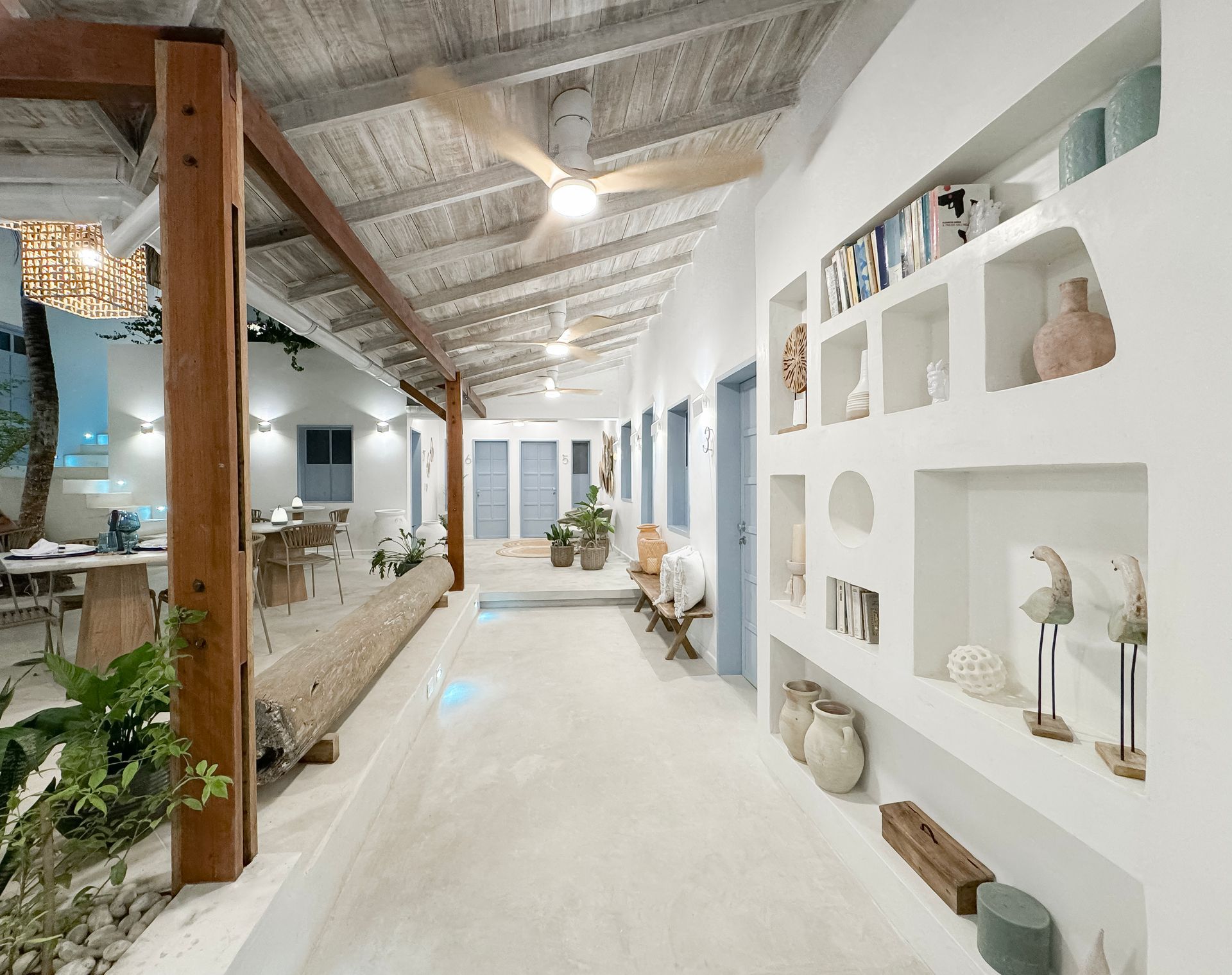 Lobby moderno y rústico en Hotel Laguna by LD Hoteles, con techos expuestos, mesas de madera y plantas decorativas.