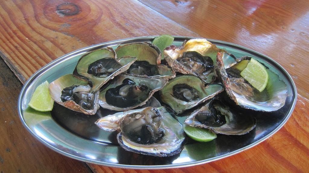 Restaurante Polito en Los Roques, especializado en mariscos frescos y ostras servidas con rodajas de lima.