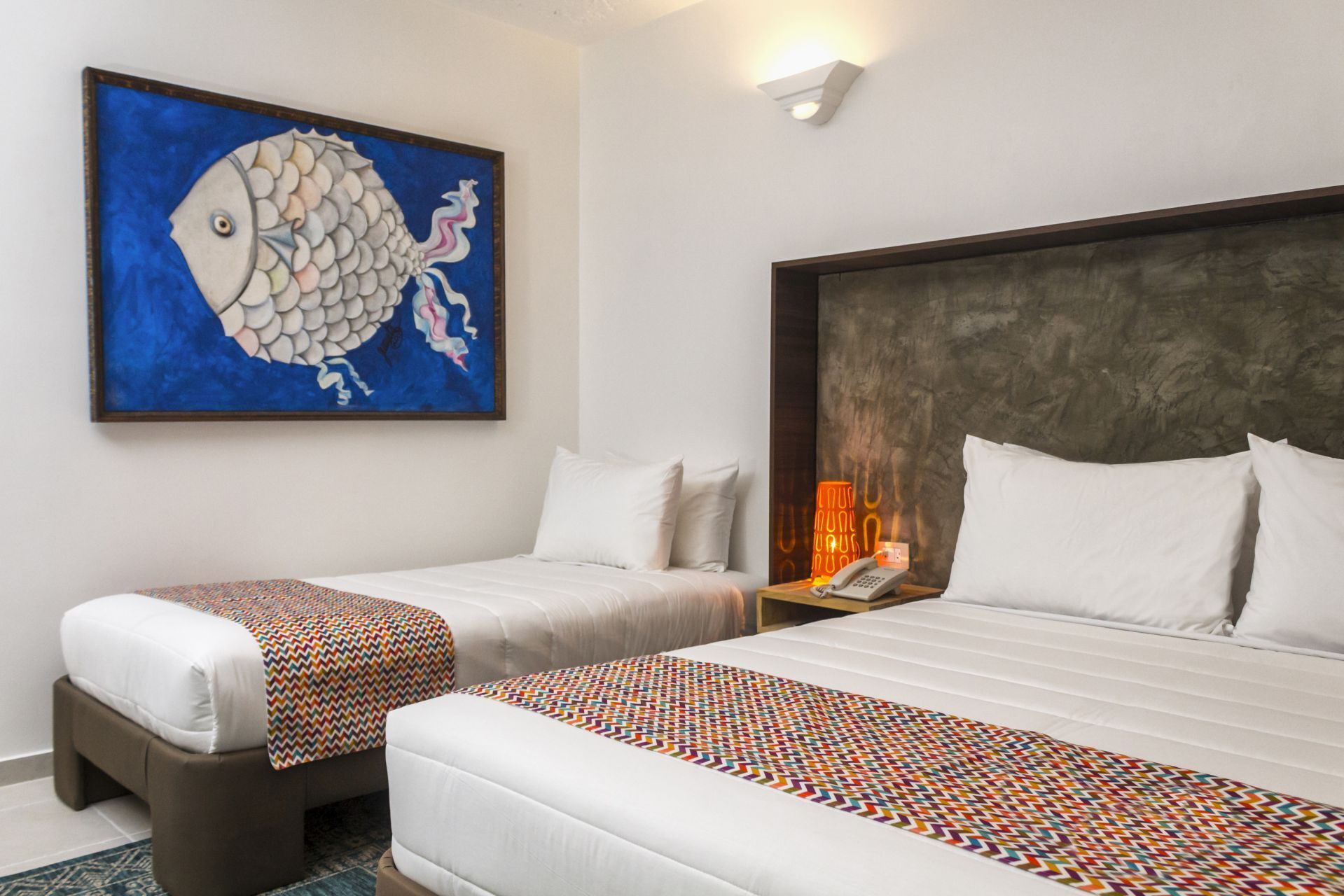 Habitación triple en LD Palm Beach, Playa El Agua, con tres camas individuales y arte marino decorativo.
