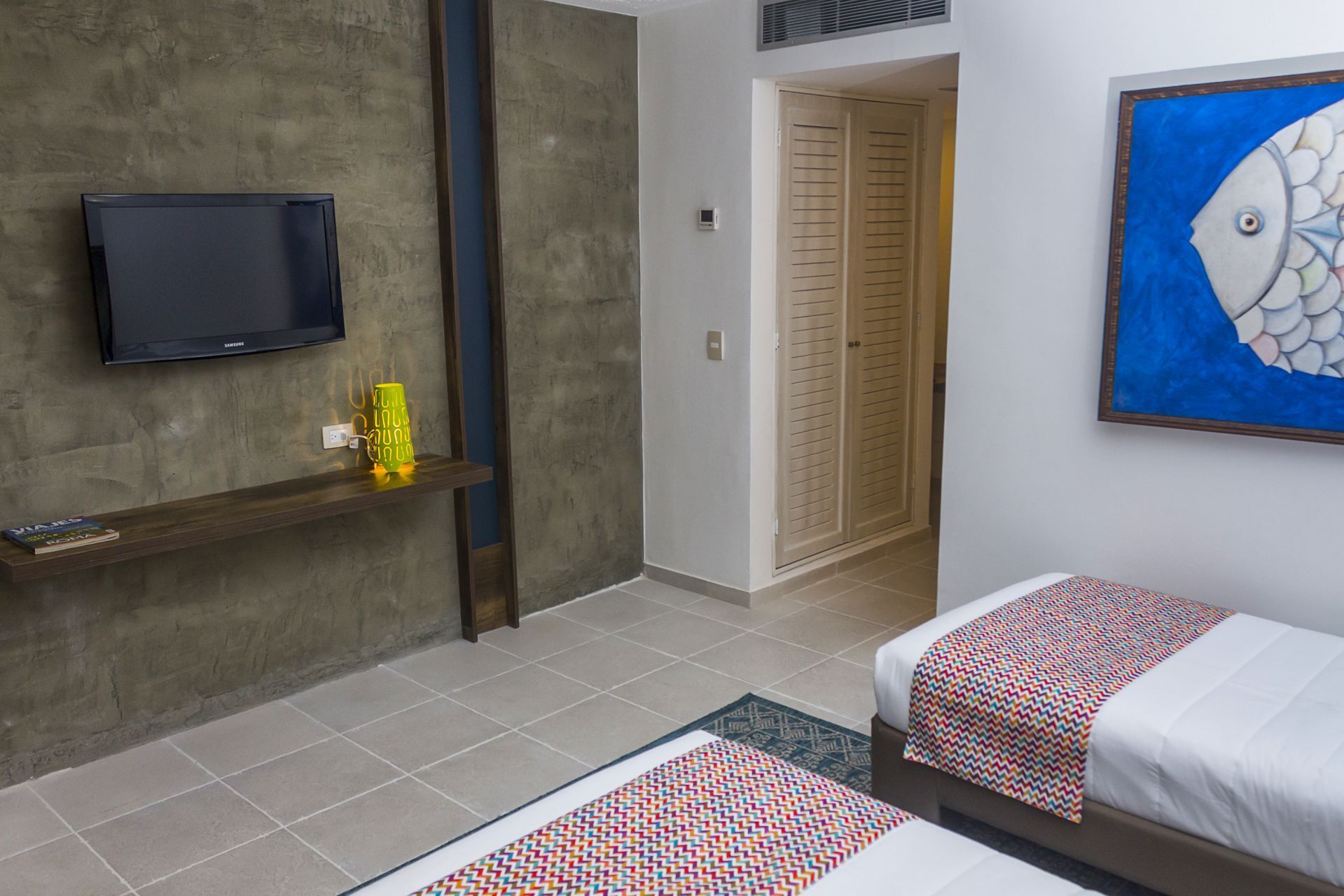 Habitación triple en LD Palm Beach, Playa El Agua, con tres camas individuales y arte marino decorativo.
