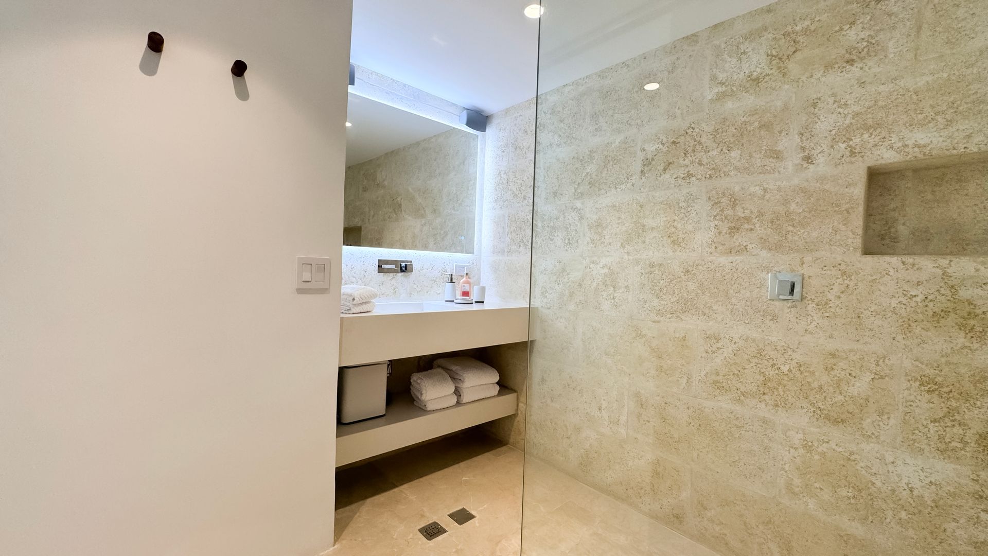 Baño habitación Deluxe King en Macanao Lodge, con cama grande, decoración elegante y baño abierto, para una estancia de lujo.