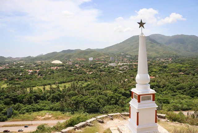 Monumento histórico cerro Matasiete en Isla Margarita, rodeado de verde naturaleza bajo cielo nublado.